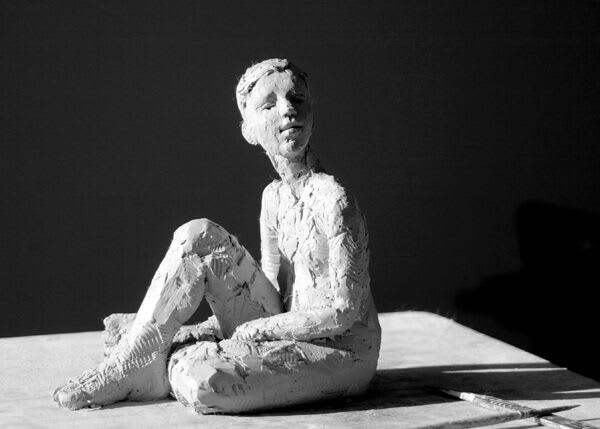 Seated female iron resin sculpture