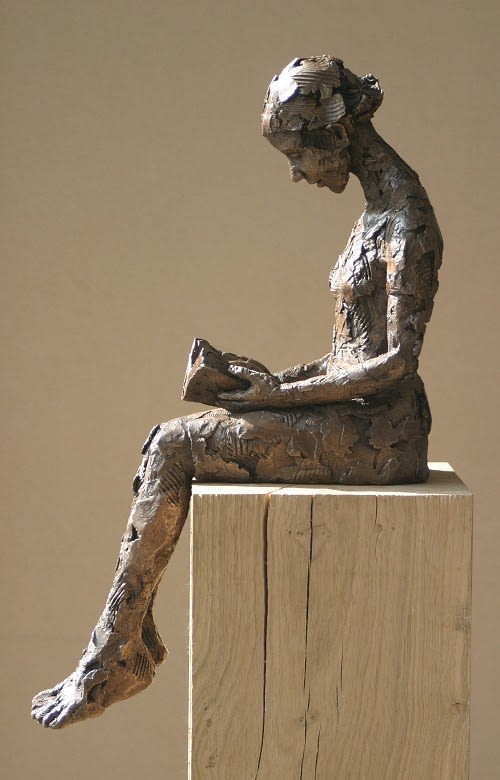 Bronze sculpture reading a book