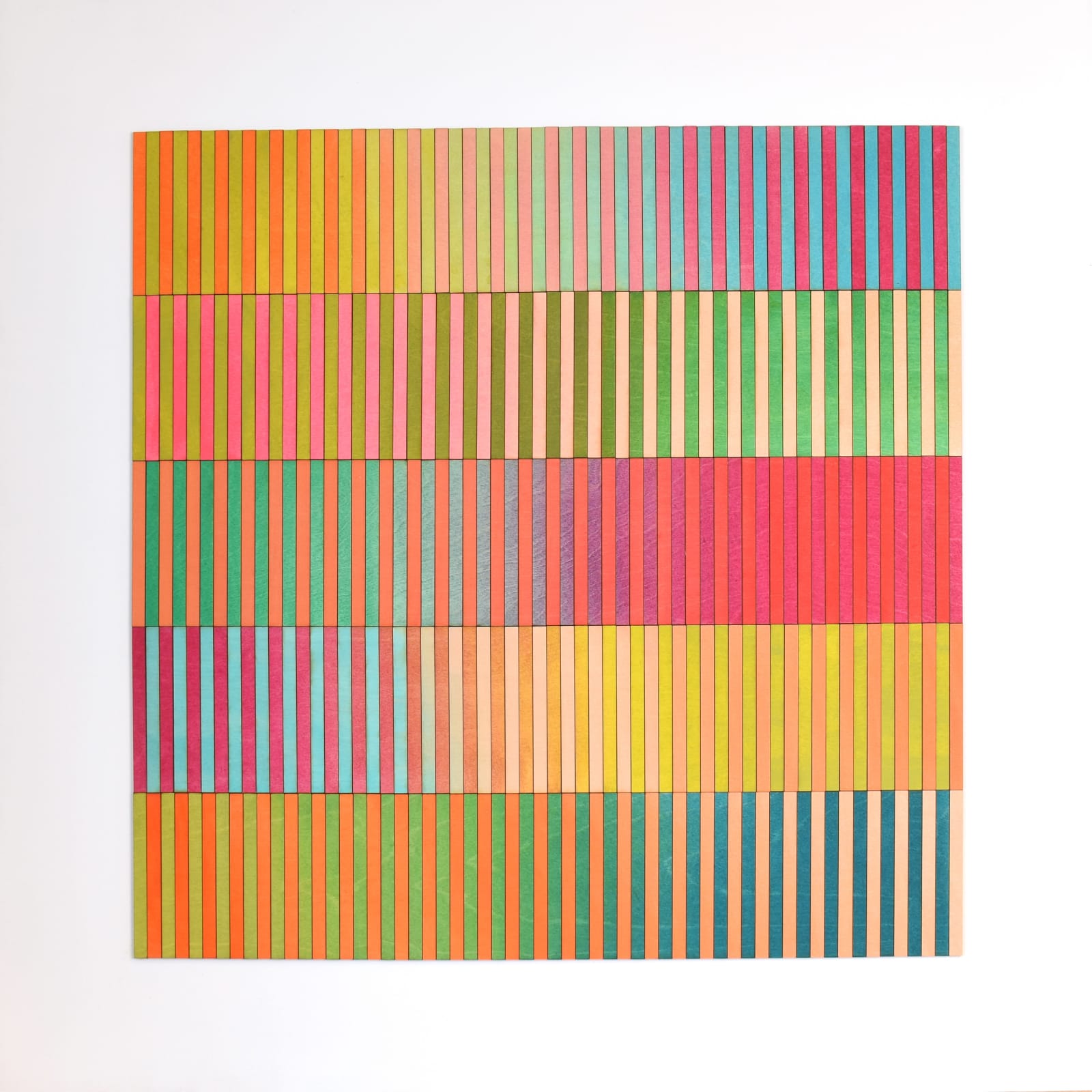 A geometric artwork composed of vertical coloured stripes arranged in horizontal bands. Each band features a different palette, with vibrant hues such as pink, orange, green, blue, and yellow. The stripes are evenly spaced and mounted on a white background, creating a bold, rhythmic composition.