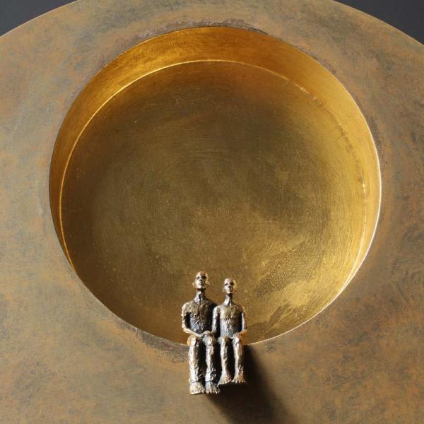 Bronze couple sitting inside a sculpture