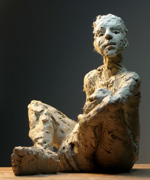 Seated male iron resin sculpture