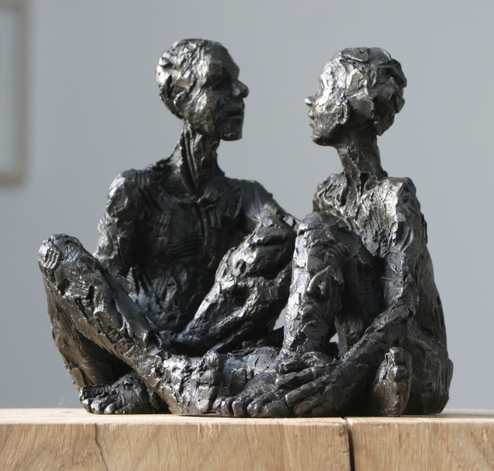 Seated Male & Female iron resin sculptures