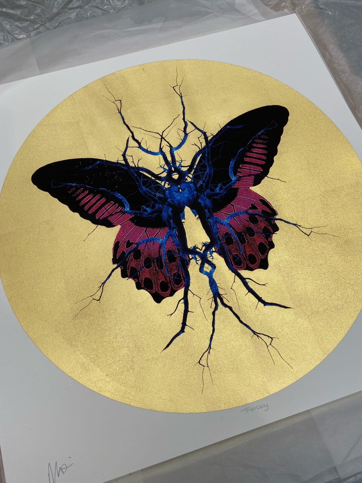 Purple, black & blue electric butterfly on gold leaf background circular background
