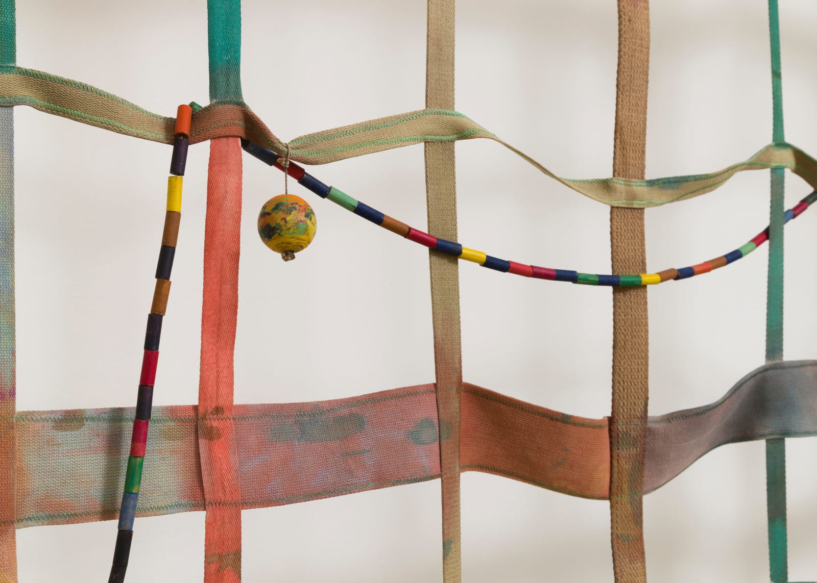 detail of a large gridded painting hanging off the wall