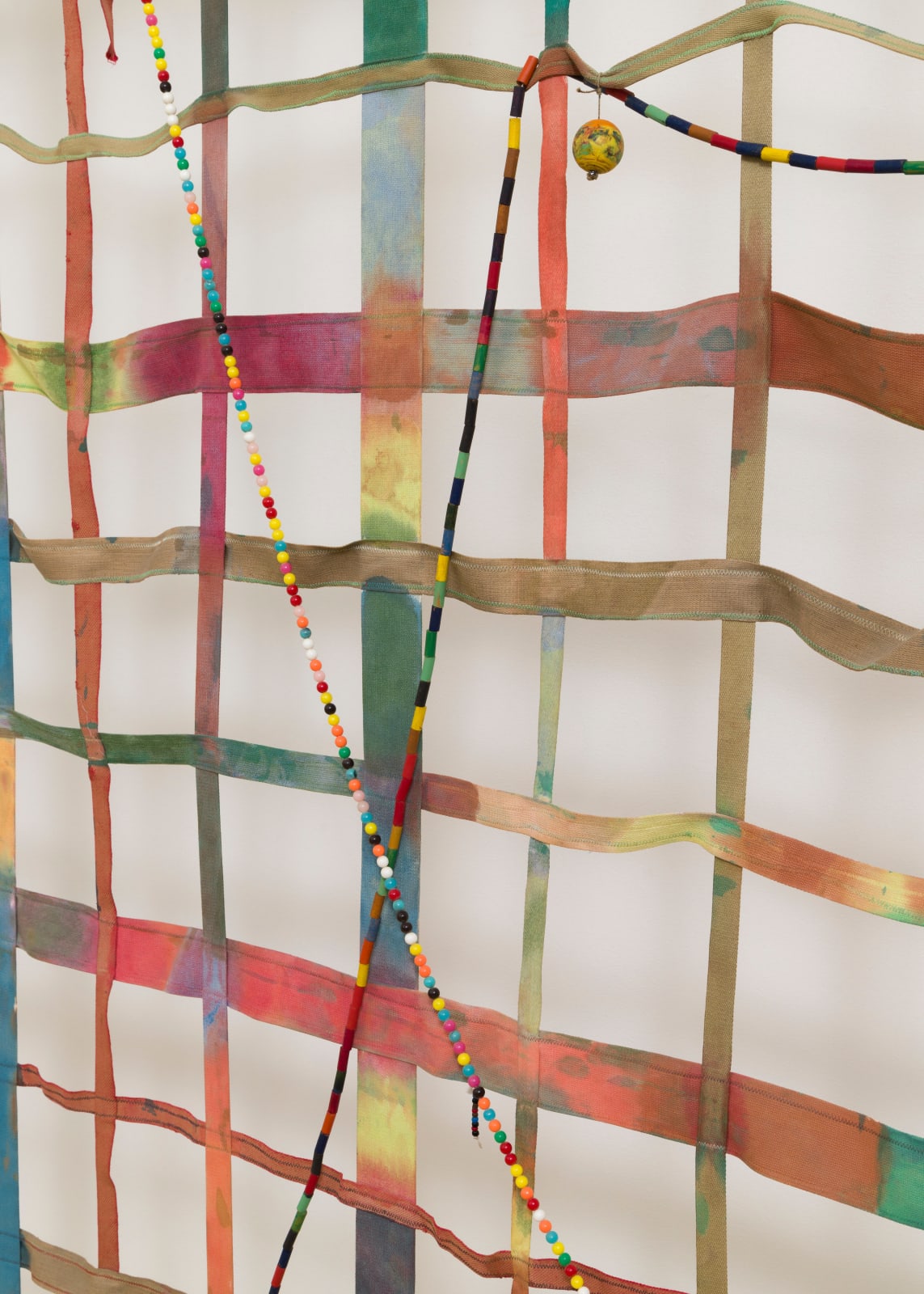 detail of a large gridded painting hanging off the wall