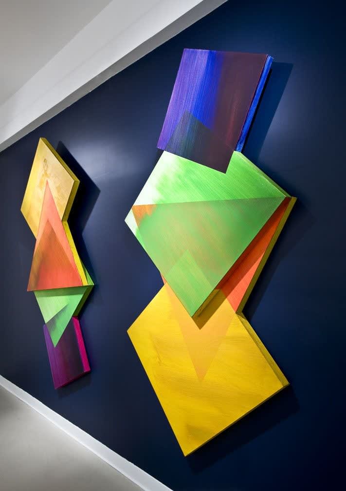 a blue painted wall with two diamond shaped paintings