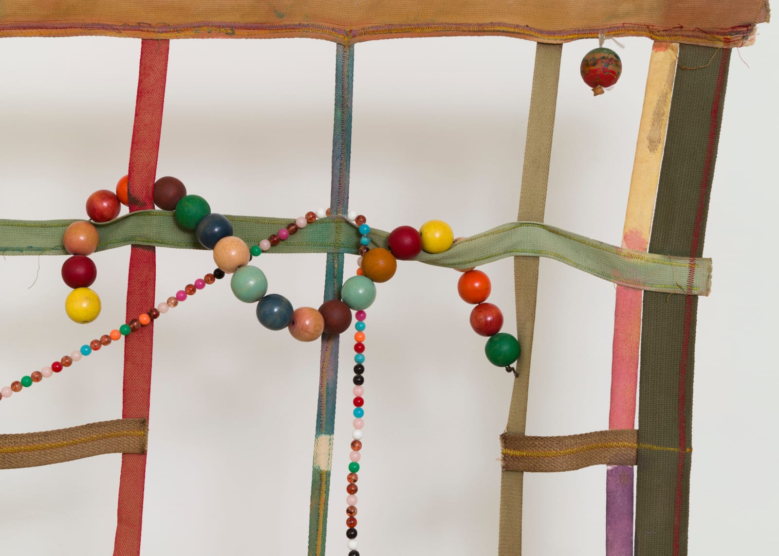 detail of a large gridded painting hanging off the wall