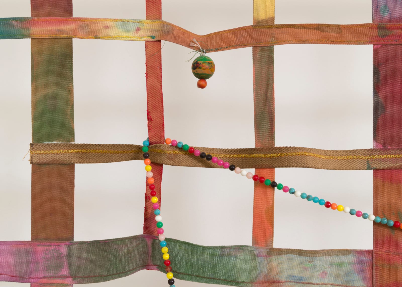 detail of a large gridded painting hanging off the wall