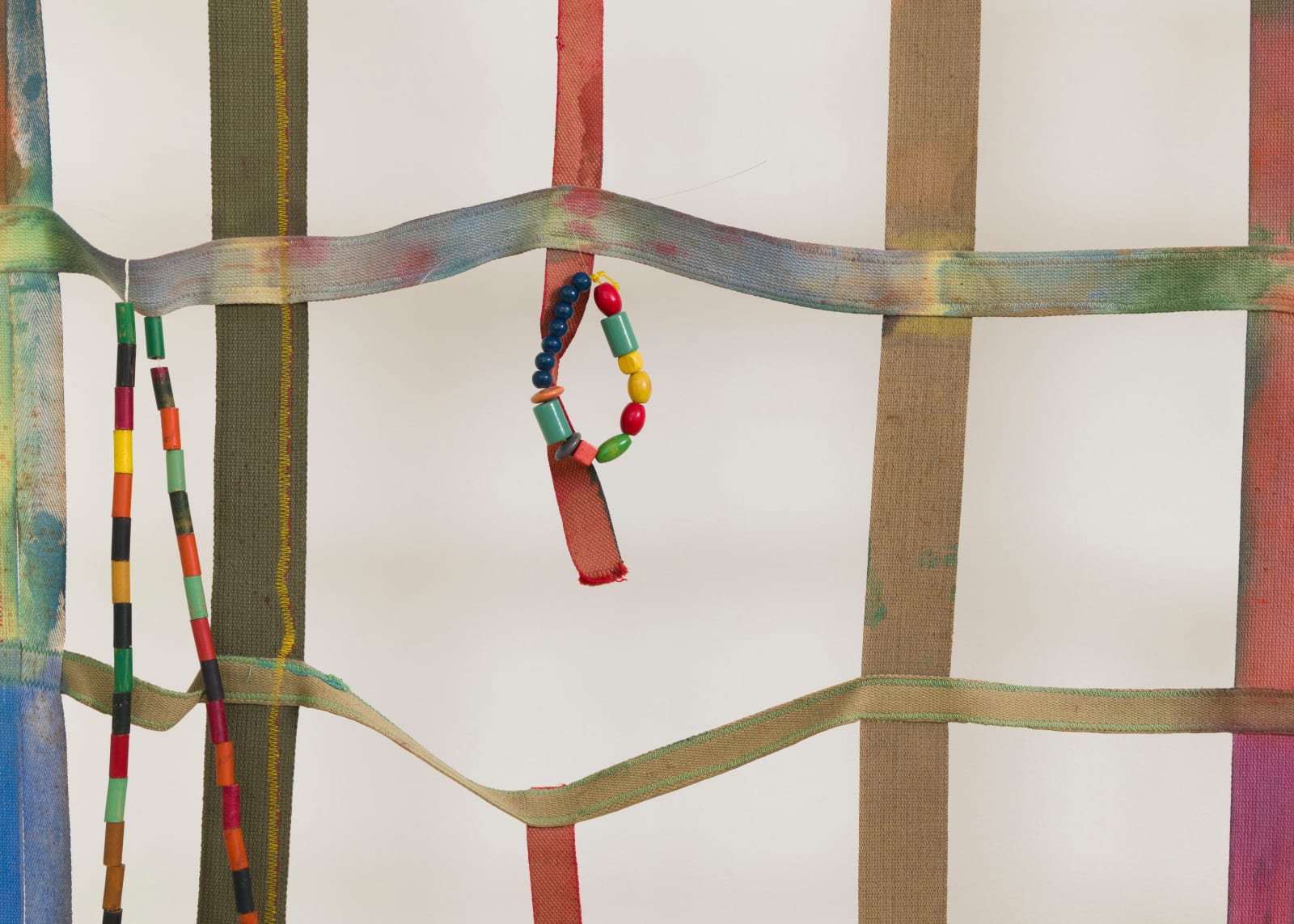 detail of a large gridded painting hanging off the wall