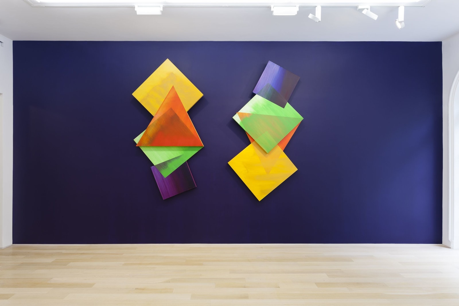 a blue painted wall with two diamond shaped paintings