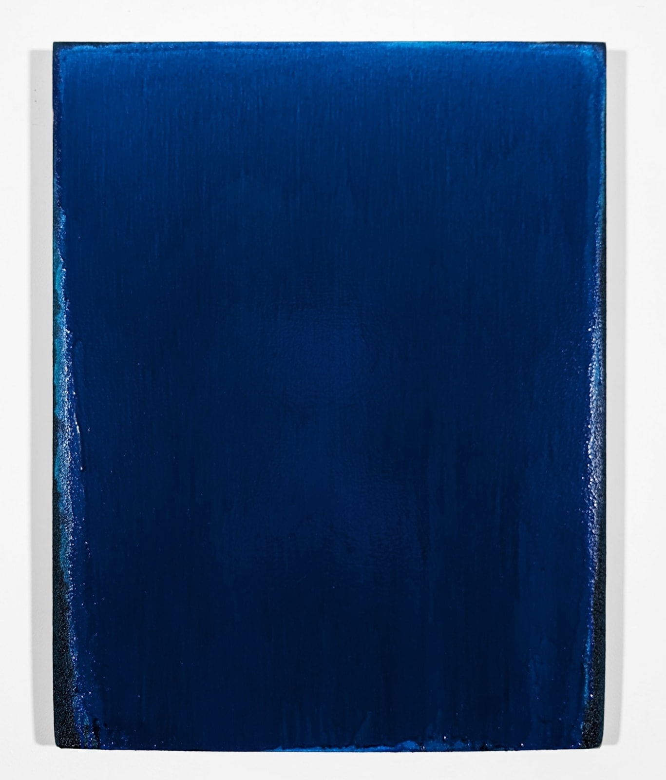 Acrylic painting on linen of a blue pigment which oppupies all of the field apart from the left and right sides and bototm corners, which are speckled with white and black as if the blue pigment has corroded along the linen's edges.