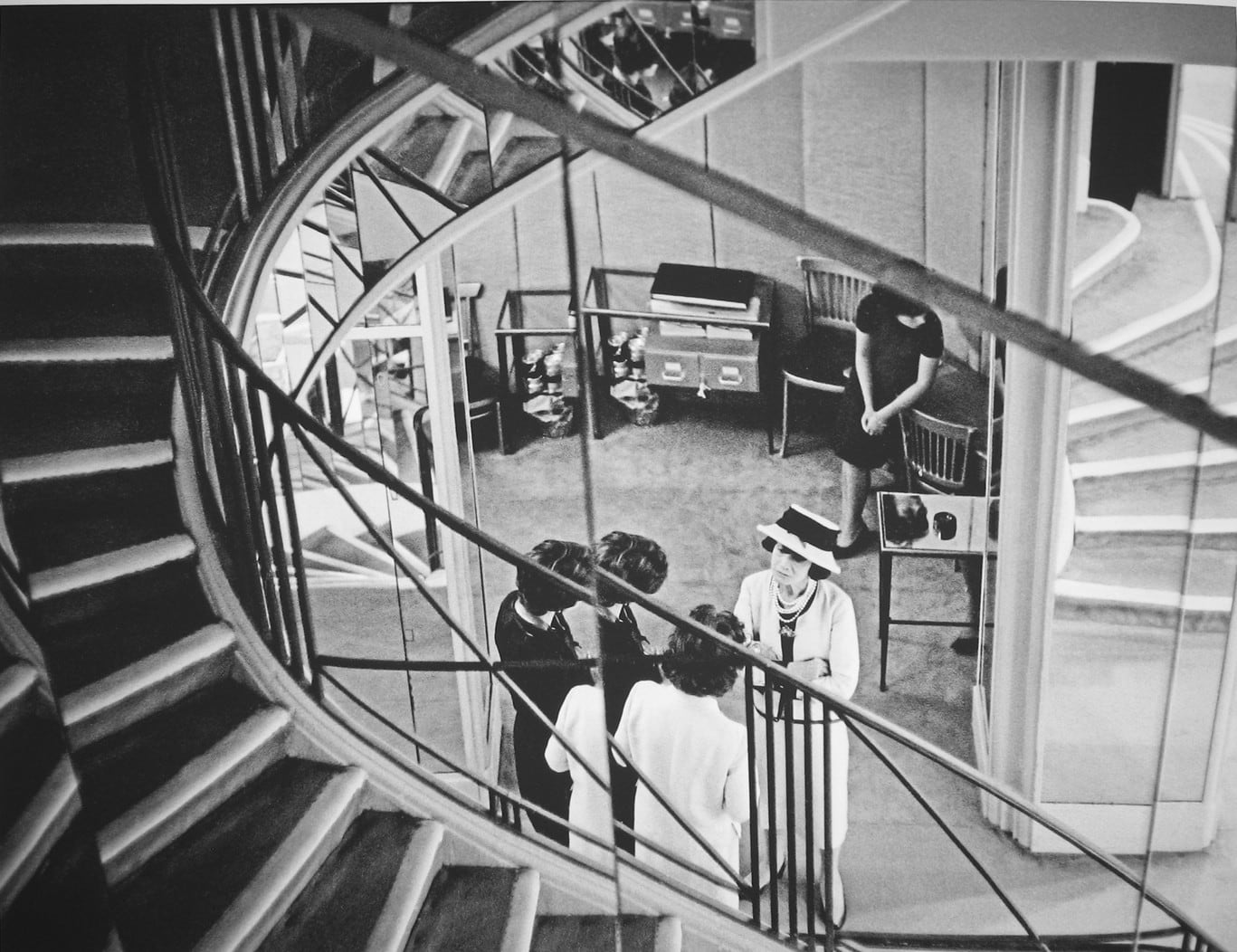 Black and white photograph of Designer Coco Chanel seen from the staircase of the House of Chanel