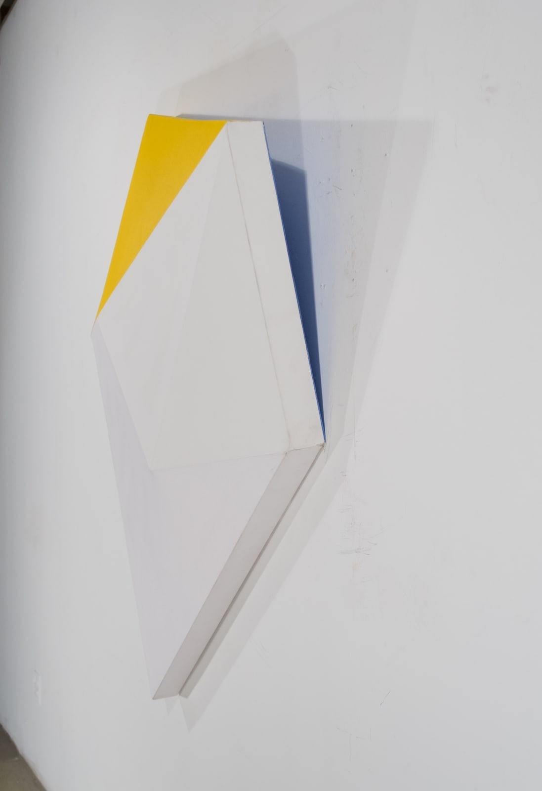 Detail of Tridimensional painting of a yellow, beige & white prism with triangular sides, looking like a cut gem