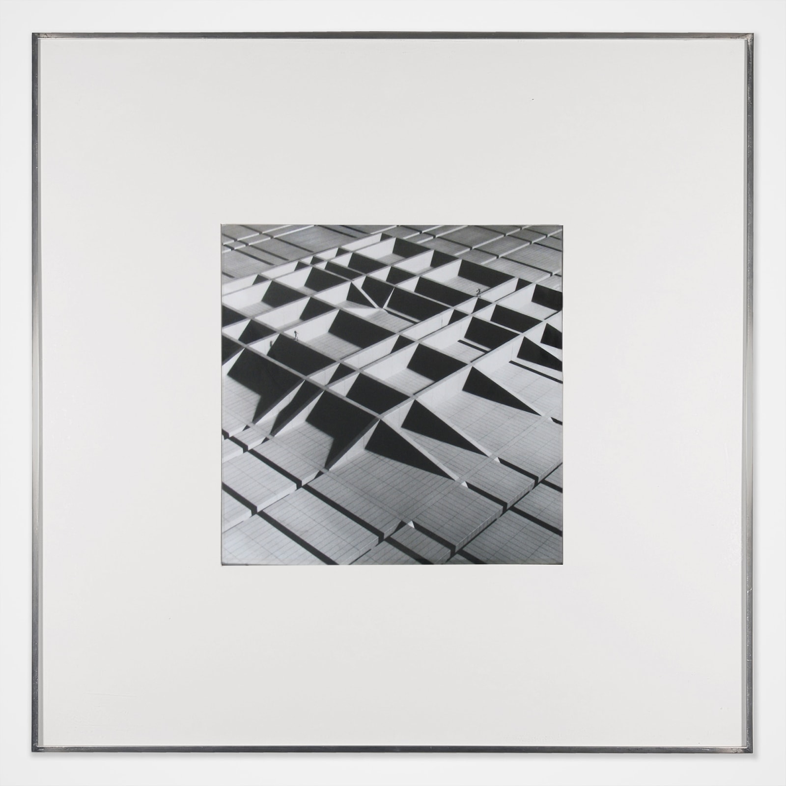 Framed Black and white photomontage of a three dimensional structure in the form of raised grid lines, viewed from above