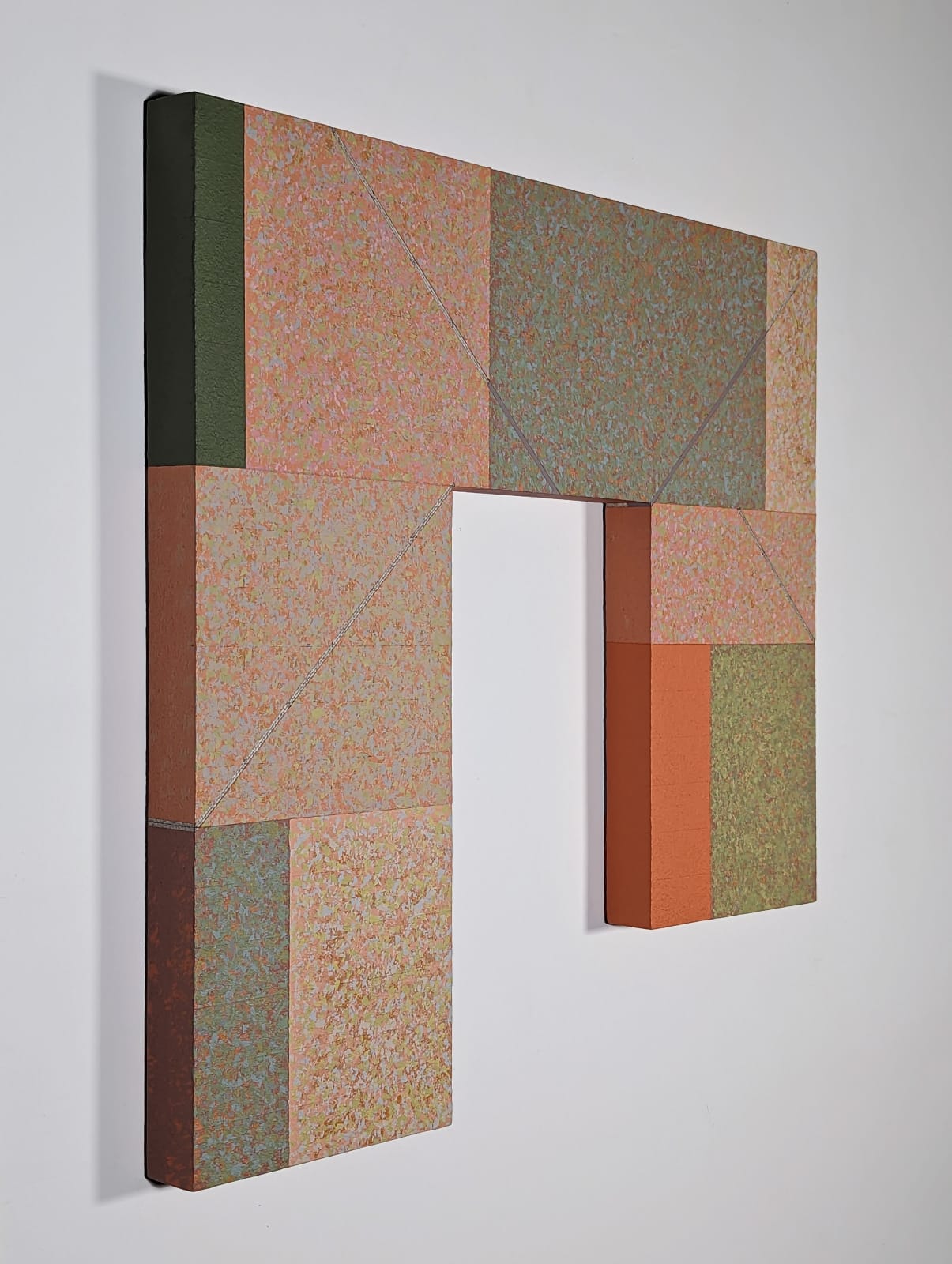 An eight-sided rectangular shape is divided into rectangular parcels of muted pink, blue, green, orange, and yellow acrylic