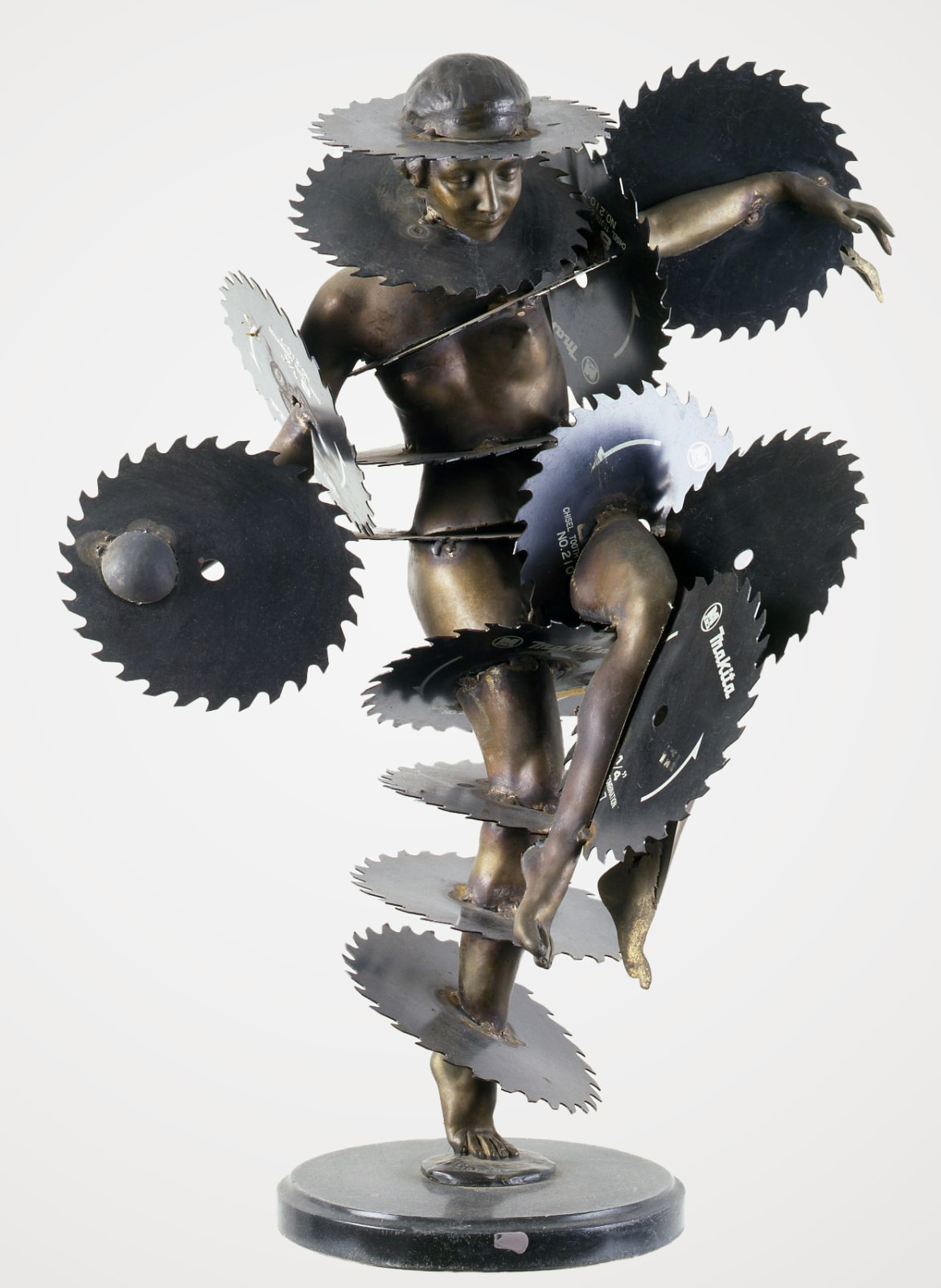 A bronze sculpture of a nude woman with circular saw blades intersecting her body at numerous points