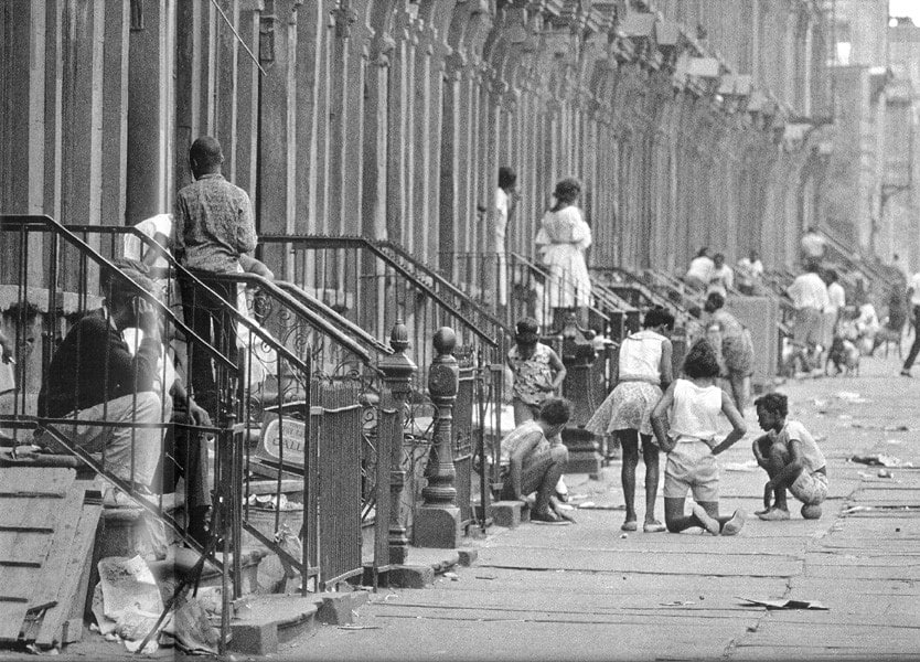 Black and white photograph of adults and children on the stoops and streets of Bedford Stuyvesant, Brooklyn
