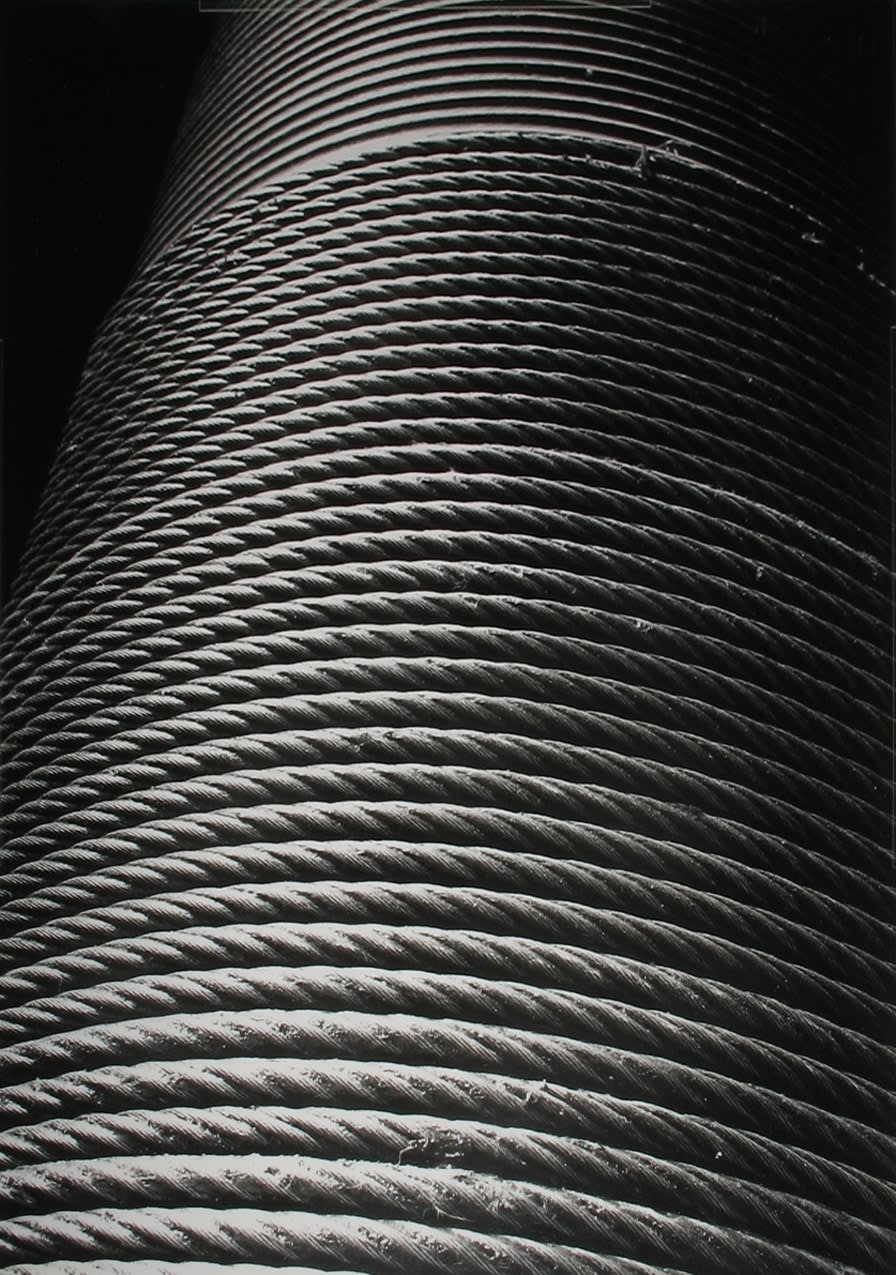 Black and white close-up photograph of a rope coiled in a cylinder shape
