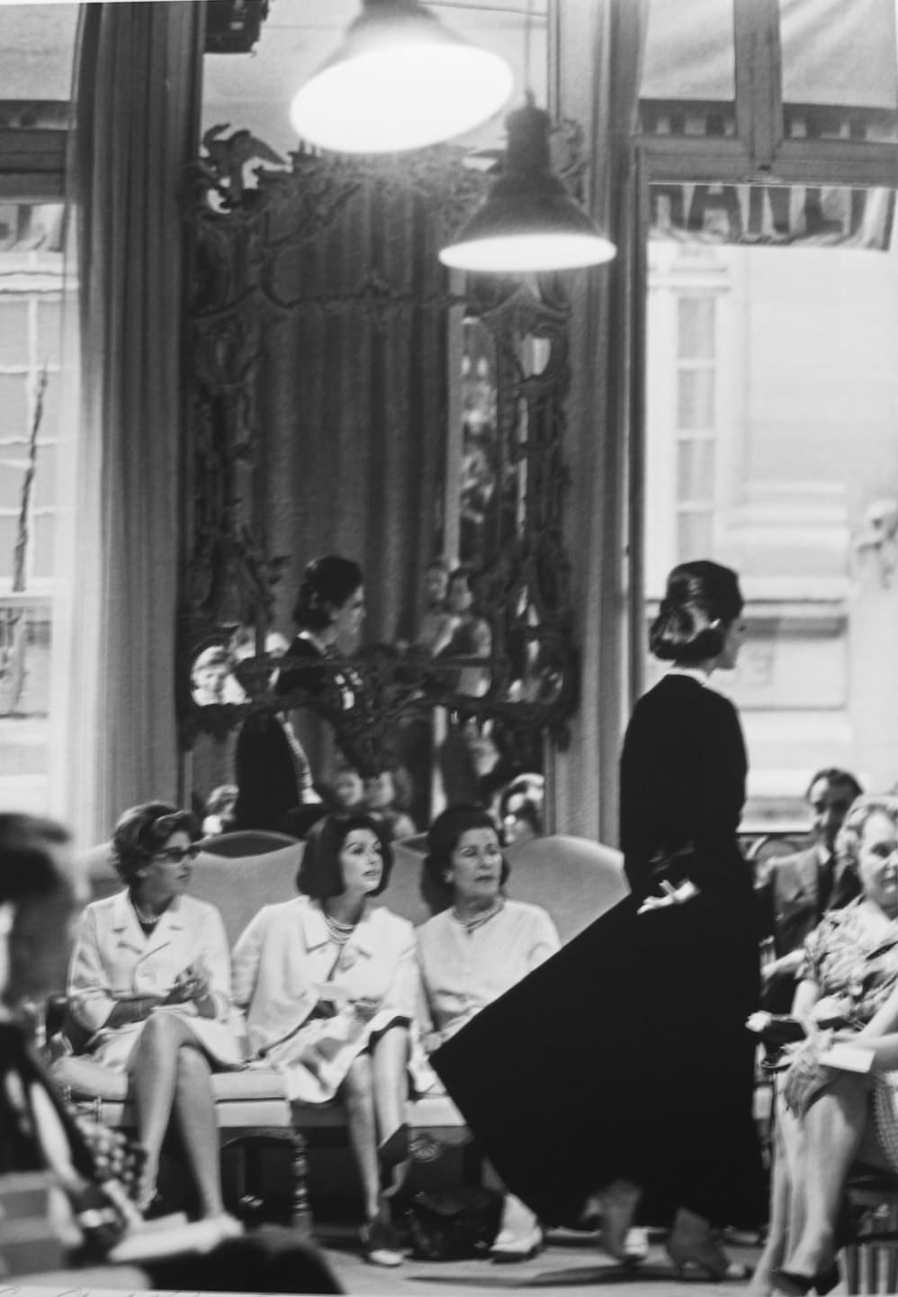 Black and white photograph of a fashion show at the House of Chanel