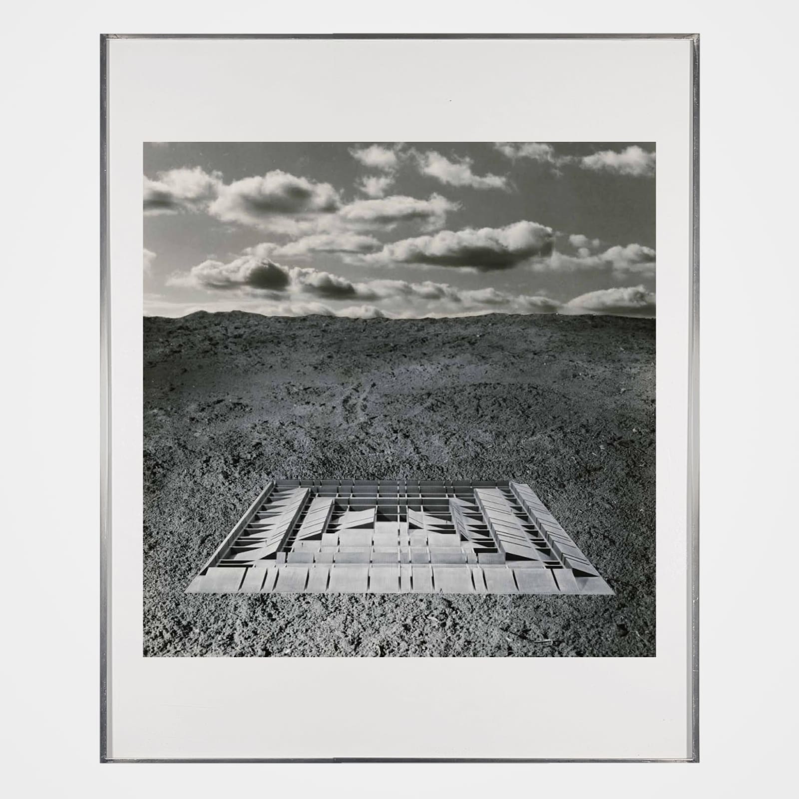 Framed black and white photomontage of an abstract structure in a baren landscape