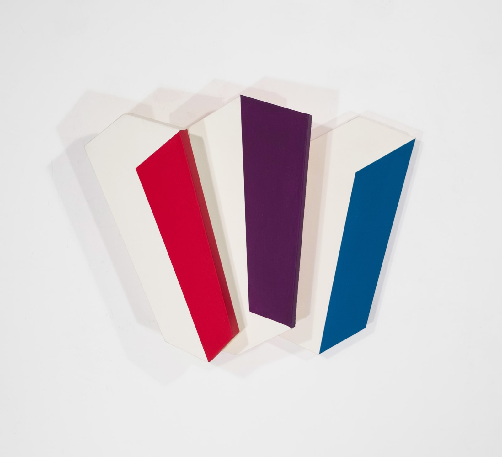 Tridimensional painting of 3 interconnected white prisms at varying angles with one face in color: red, purple, blue