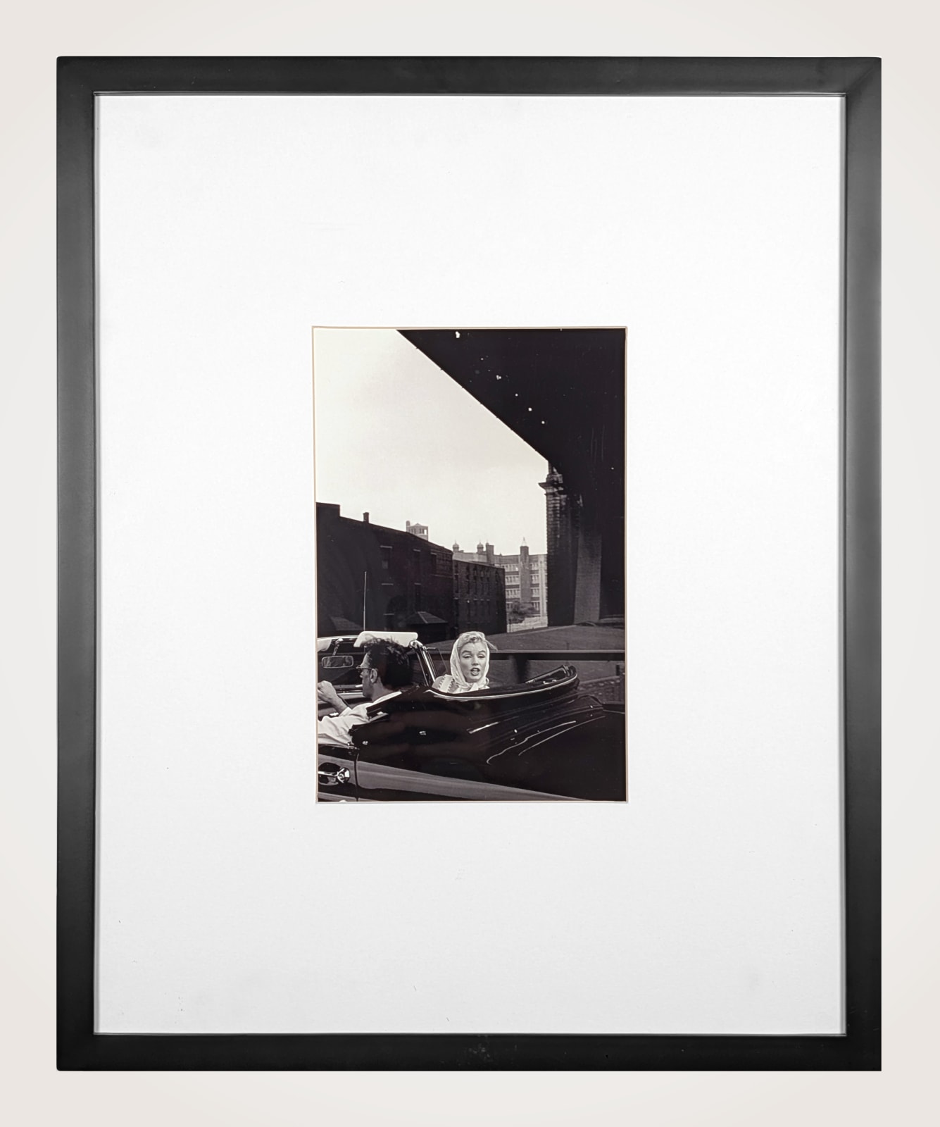 Framed black and white photograph of Marilyn Monroe and Arthur Miller driving under a bridge in a Thunderbird convertible