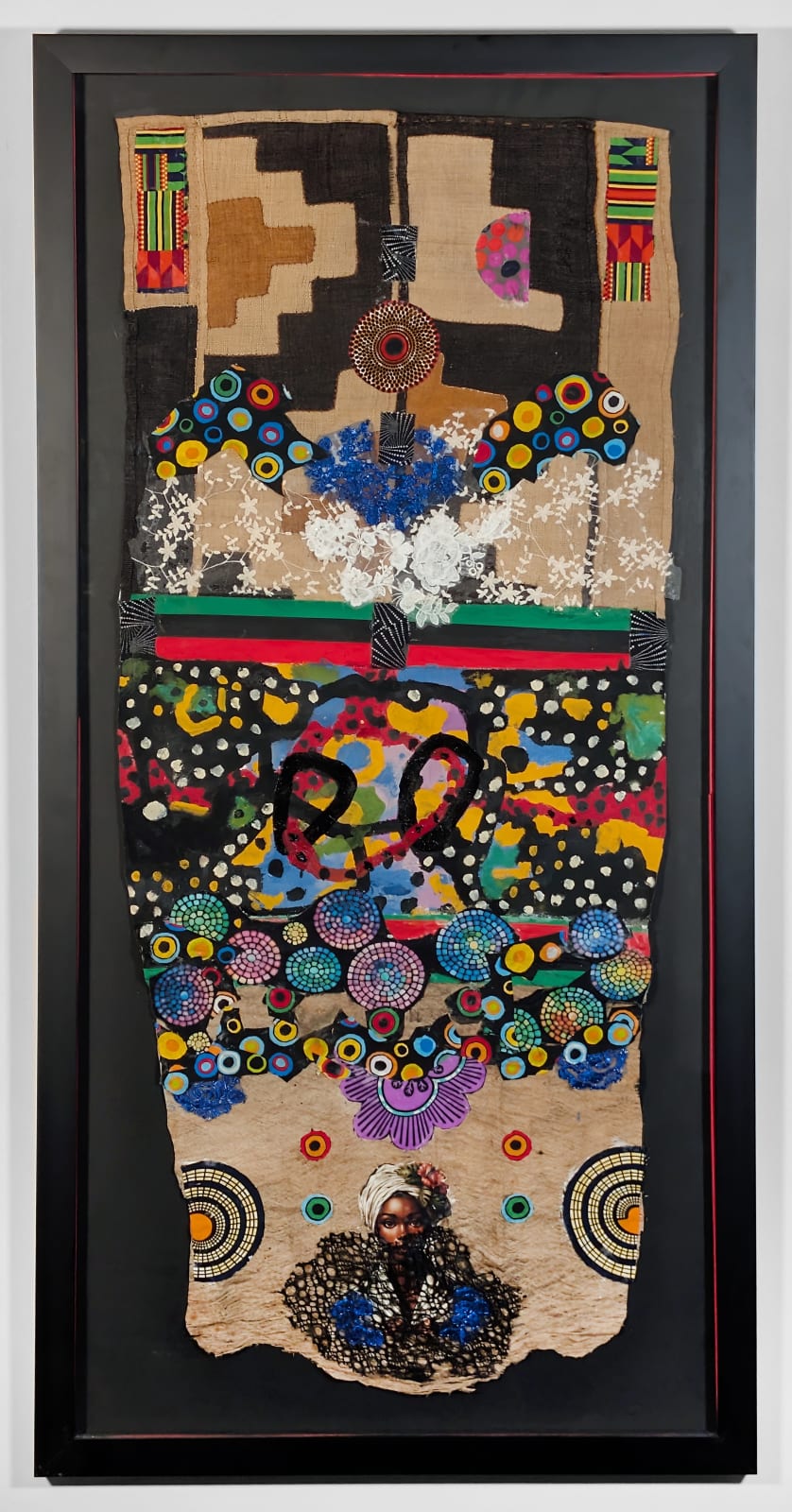 Black framed colorful artwork comprised of oil and patterned fabric on cloth in a