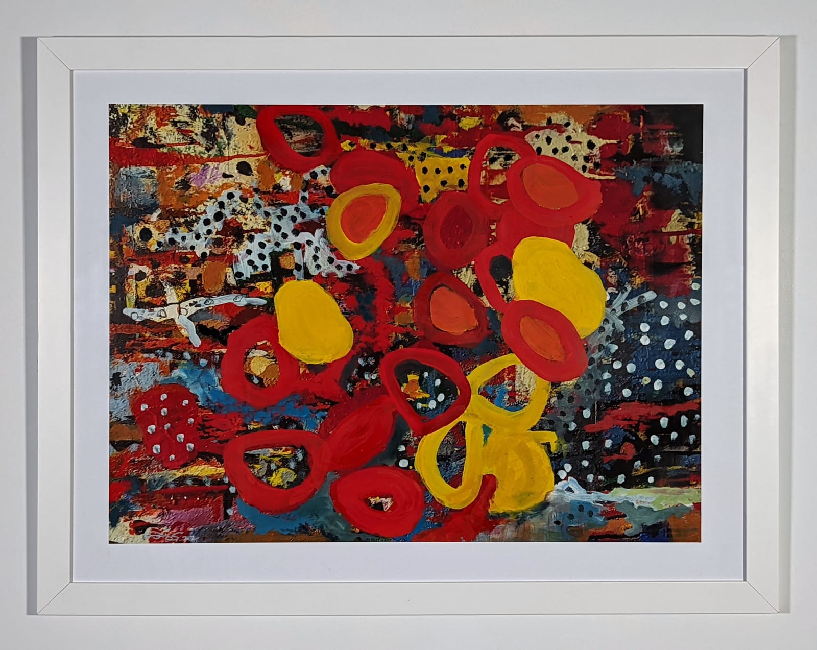 White framed colorful artwork comprised of oil and patterned fabric on print in a