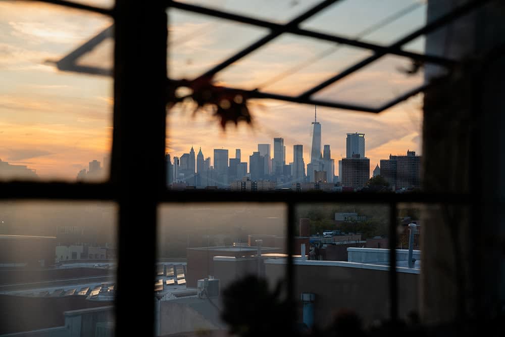 photograph of the Manhattan skyline at sunset taken through an open window