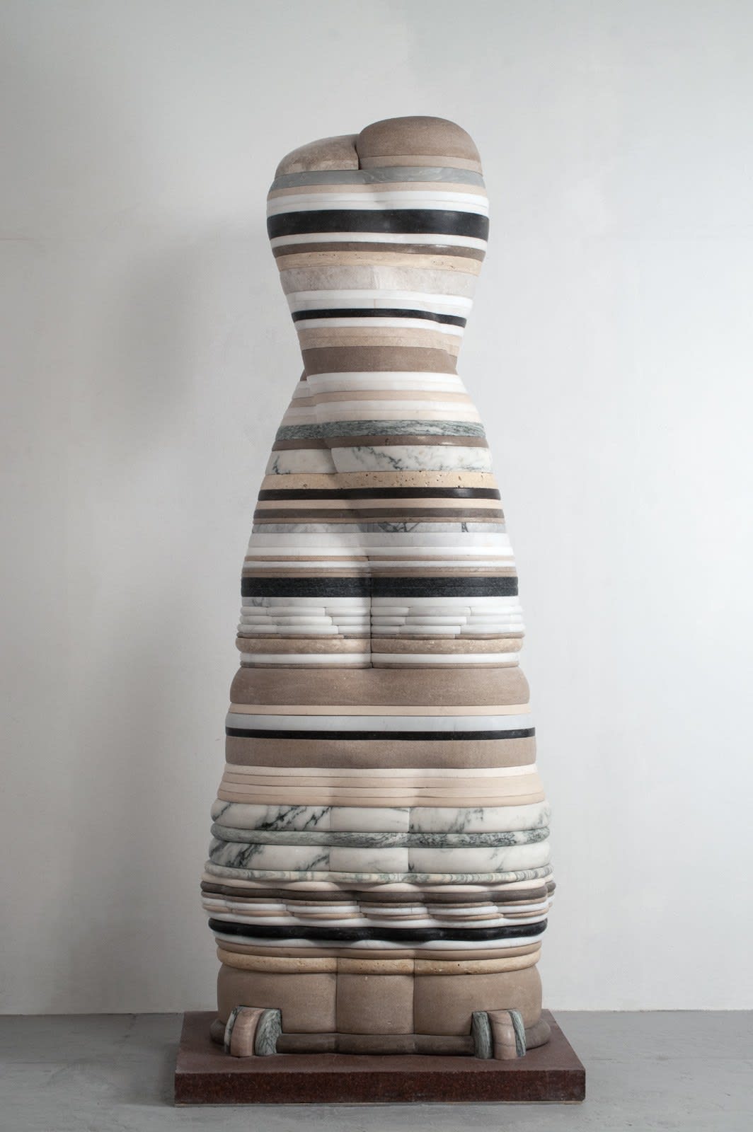 A sculpture of an abstract organic form comprised of thin layers of marble and limestone with two small abstracted