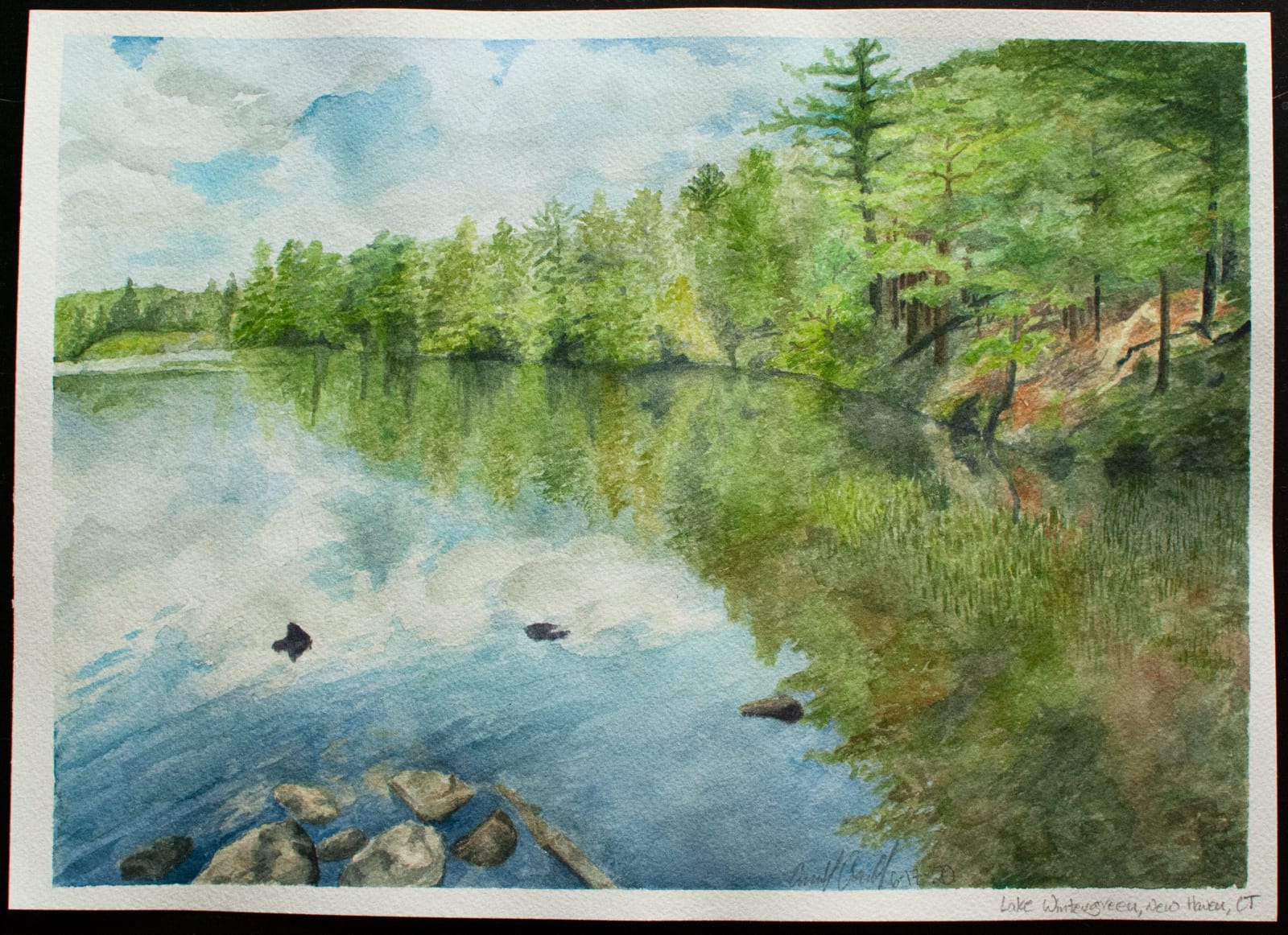 A watercolor print of a lake in a park