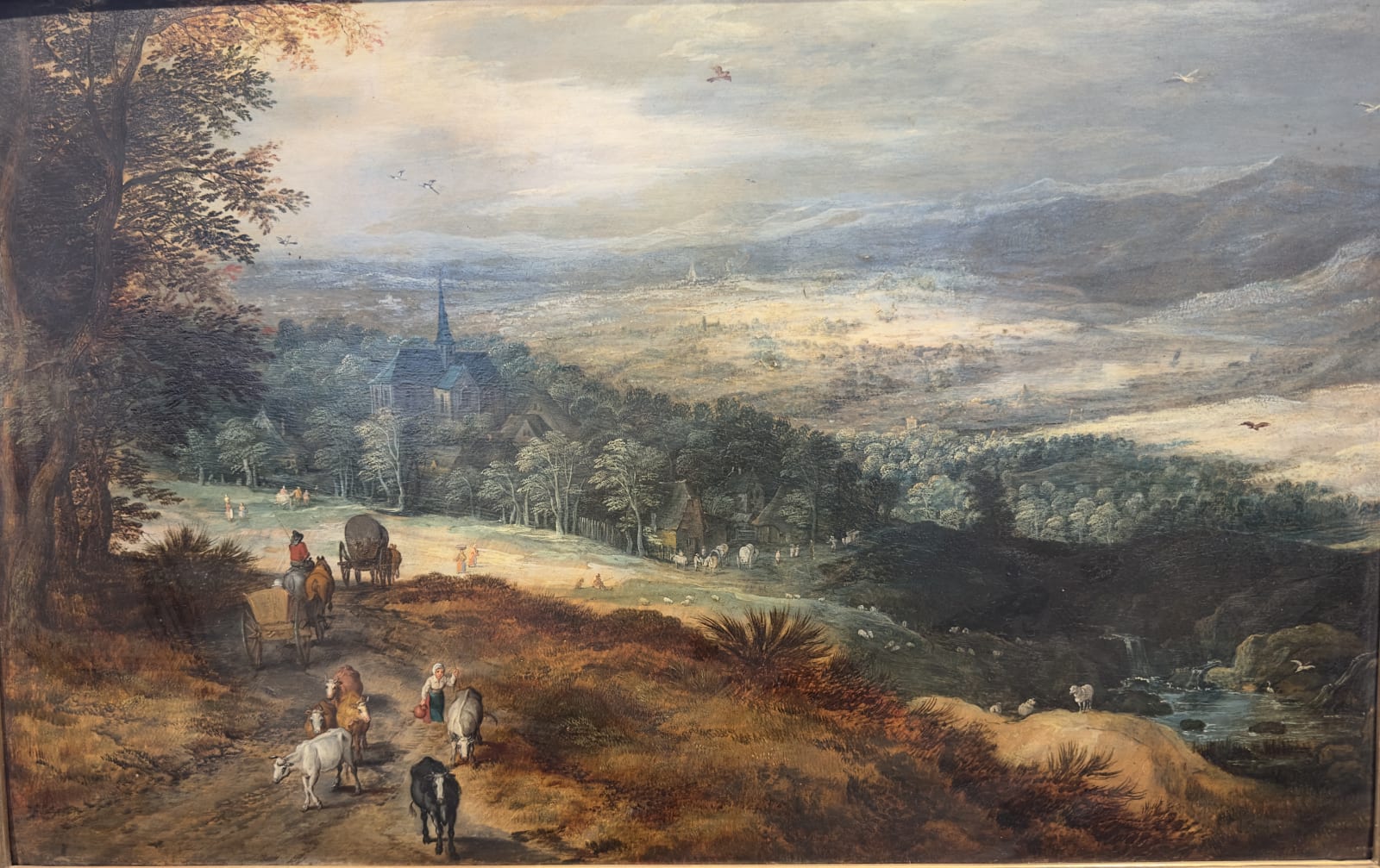 Joos de Momper (Antwerp 1564 - 1635) , A hilly Landscape with Travellers; a Village beyond