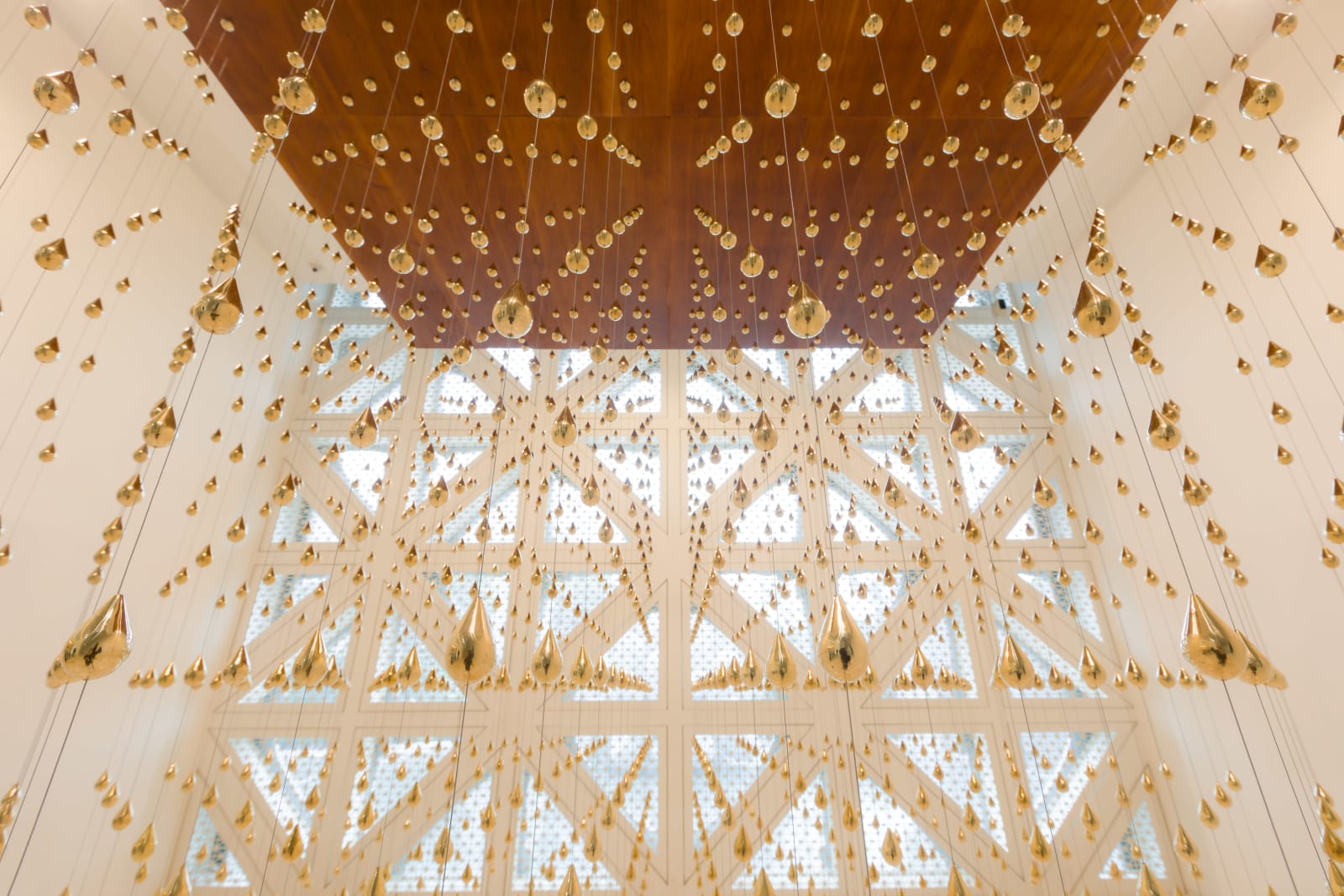 Arin Rungjang, Golden Teardrop (Cubic), 2025, Site-specific sculptural installation with cast brass pieces and wooden plate ceiling, 240 x 240 x 243 cm Images courtesy of the artist and MOCA Bangkok.