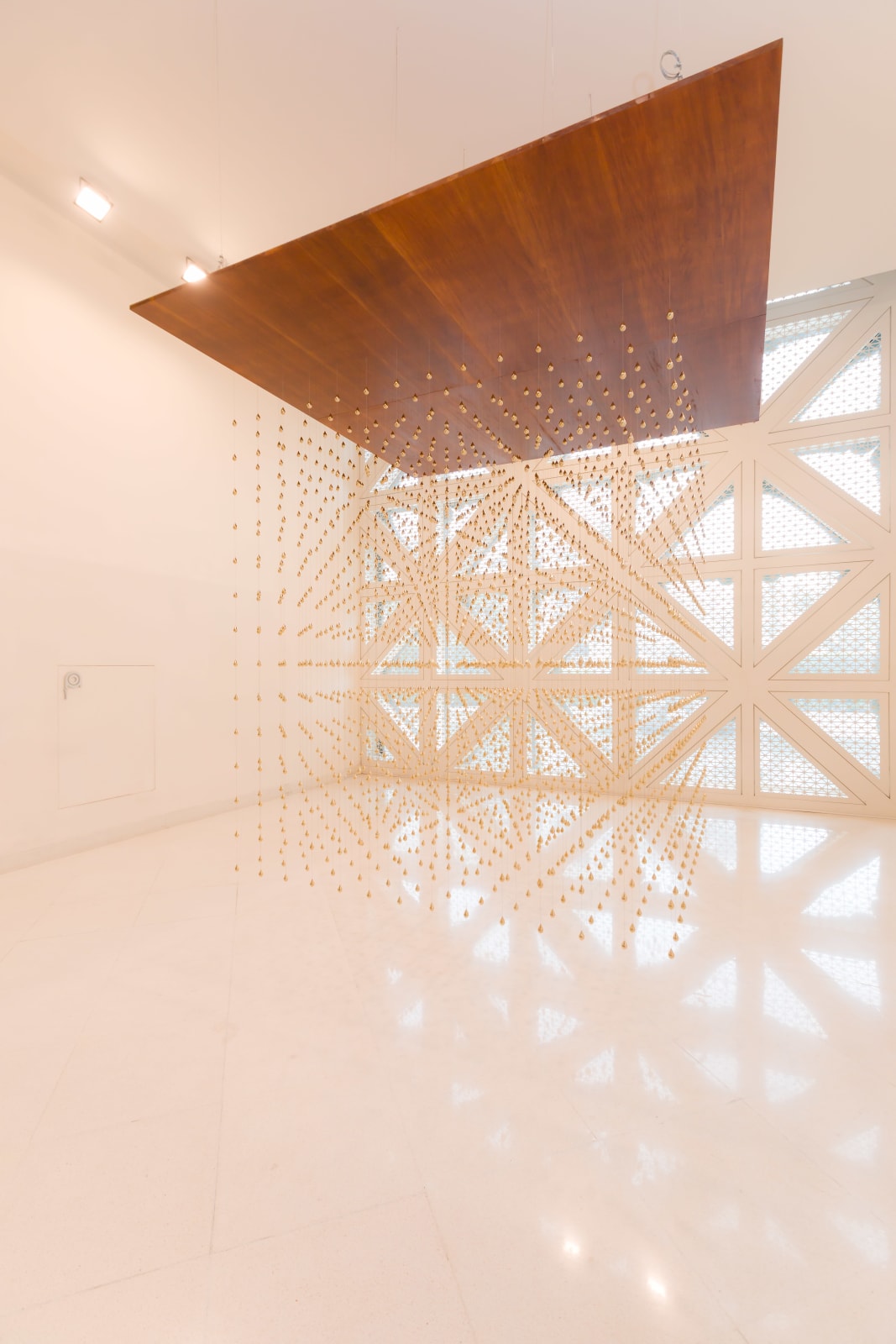Arin Rungjang, Golden Teardrop (Cubic), 2025, Site-specific sculptural installation with cast brass pieces and wooden plate ceiling, 240 x 240 x 243 cm Images courtesy of the artist and MOCA Bangkok.