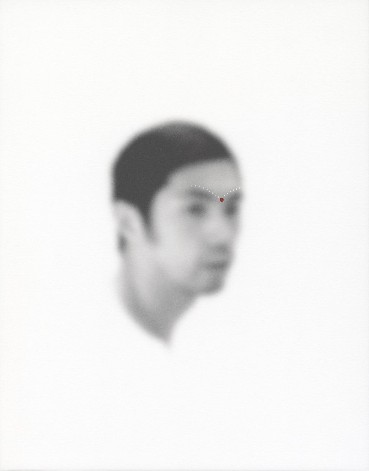 An out-of-focus portrait of a man with dots of acrylic paint on his brow