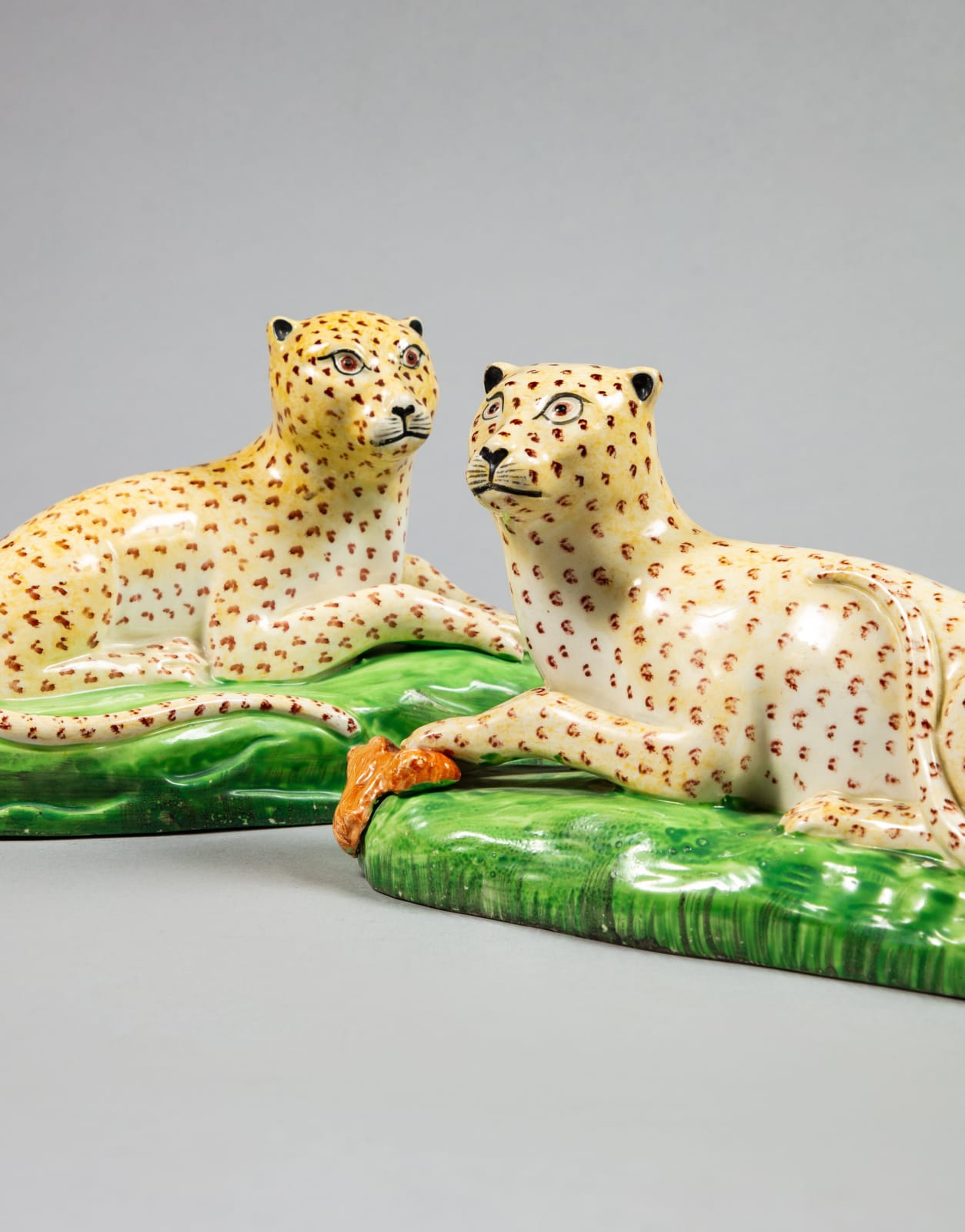 , A rare pair of Staffordshire Creamware models of recumbent Leopards, Circa 1810