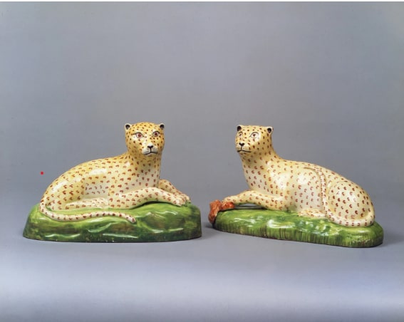 , A rare pair of Staffordshire Creamware models of recumbent Leopards, Circa 1810