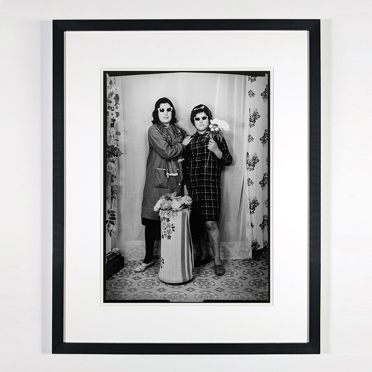 Black and white photograph of two women wearing sunglasses and posing in a photo studio in Ain Beida, Algeria