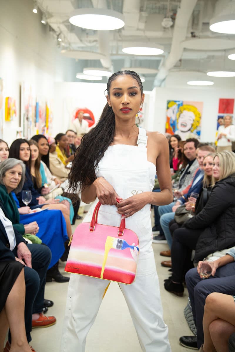 Model walking down runway in gallery space in Buckhead Village, Atlanta during the Caroline Dechamby Retrospective.