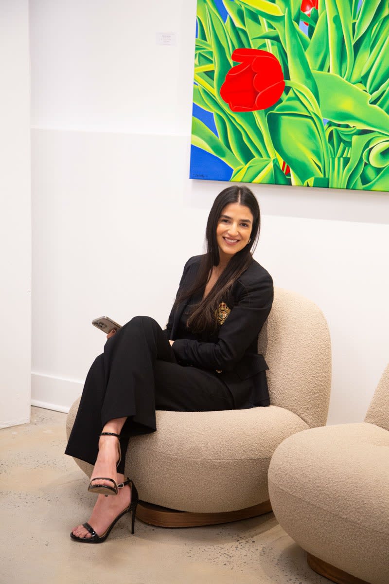 Woman posing on couch at Carousel Fine Art's gallery space in Buckhead Village, Atlanta during the Caroline Dechamby Retrospective.