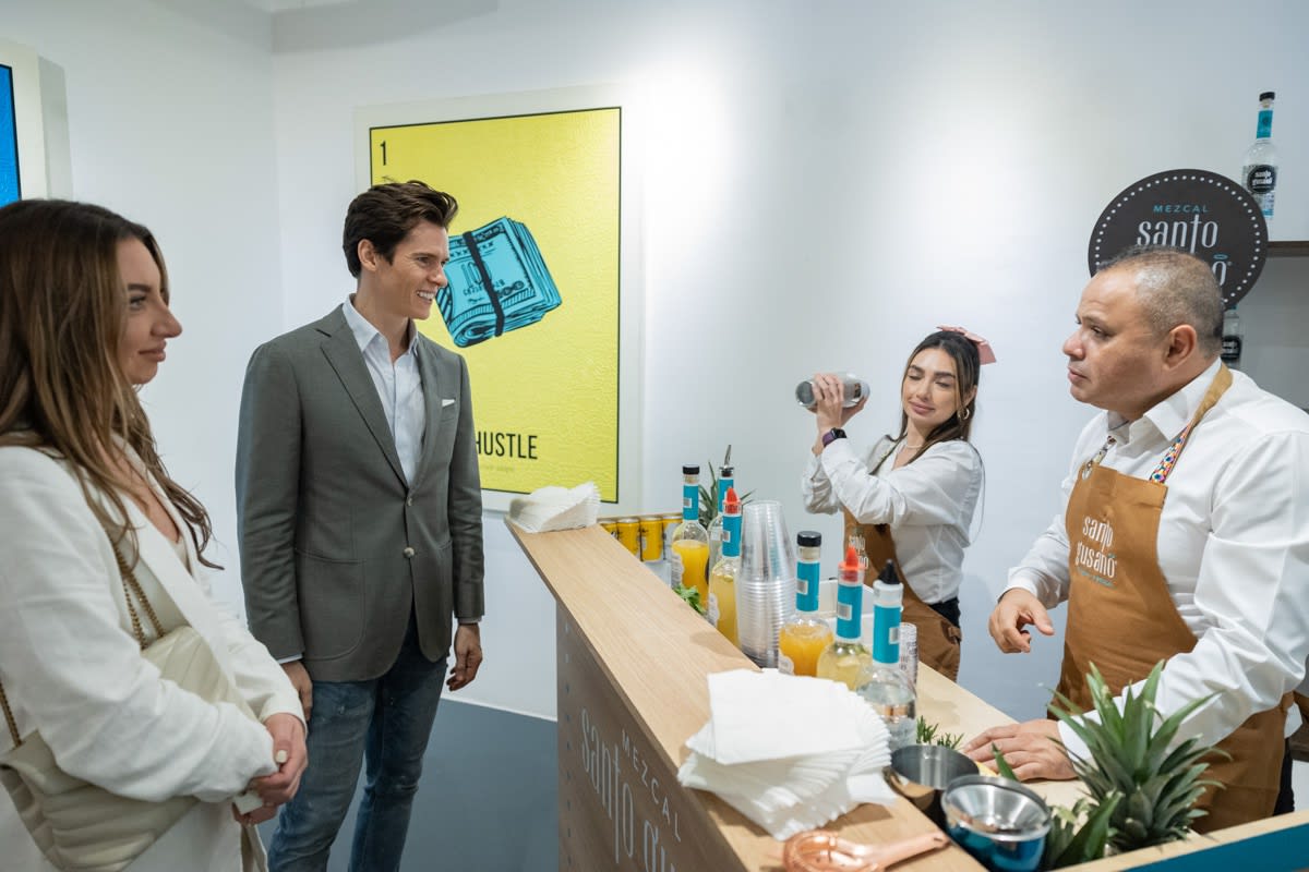 People at make-shift bar in Carousel Fine Art's Miami location for the Cayla Birk exhibition, "It's in the Cards."