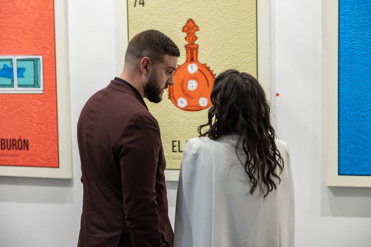 People staring at Cayla Birk's artworks displayed in Carousel Fine Art's Miami location for the Cayla Birk exhibition, "It's in the Cards."