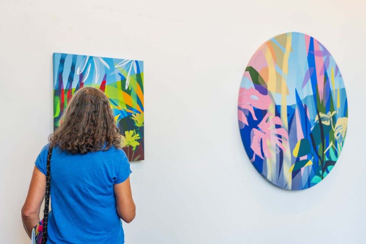 Woman looking at painting by Neill Wright displayed inside Carousel Fine Art's Miami gallery space during Neill Wright's exhibition "Where the Light Gets In."