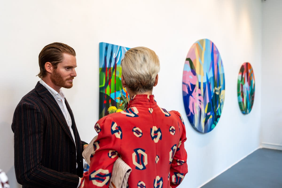 People inside Carousel Fine Art's Miami gallery space during Neill Wright's exhibition "Where the Light Gets In."