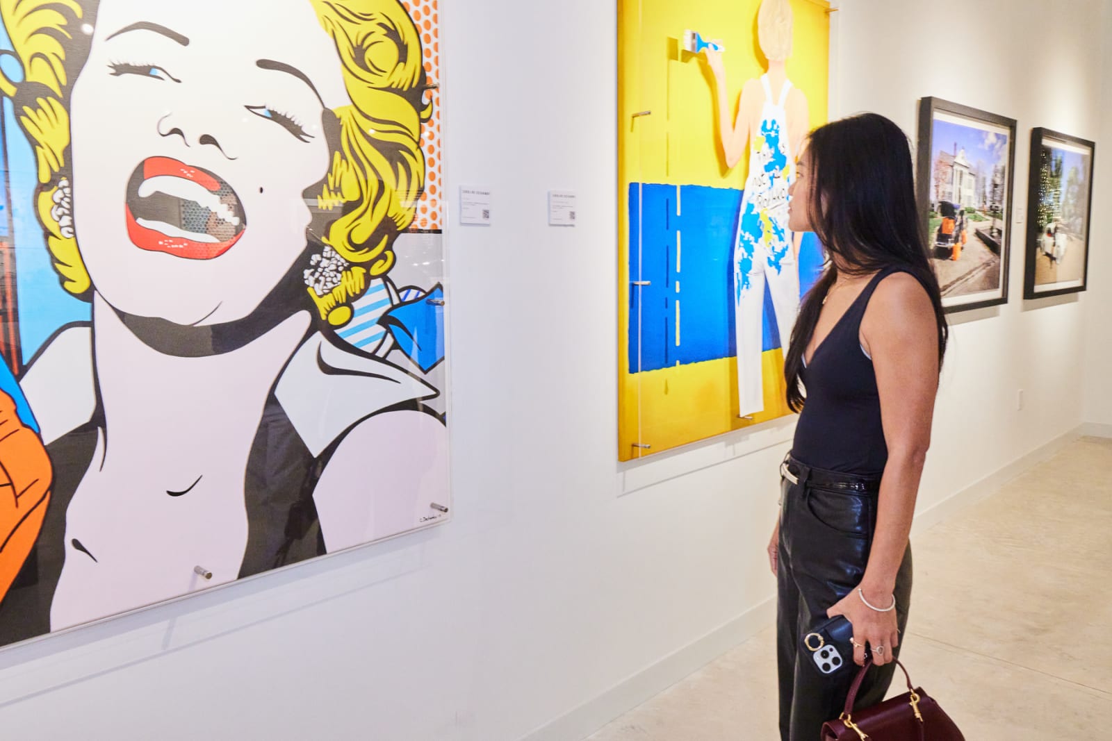 Collector leaning in to see Caroline Dechamby Marilyn Monroe work at NORA West Palm gallery.