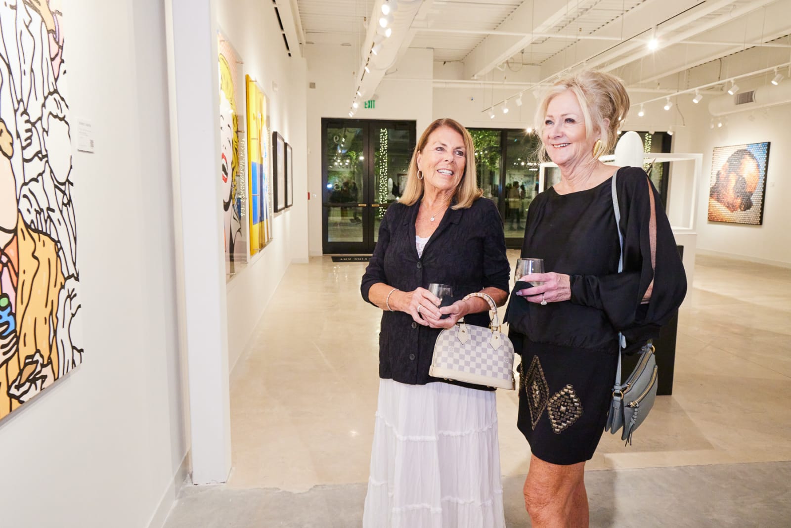 Art advisor guiding clients through Isabelle Scheltjens and Eric Alfaro works at NORA West Palm gallery.