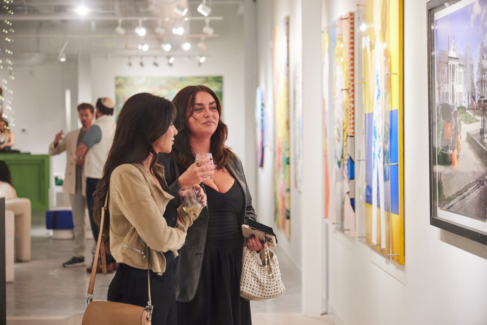 Collector pointing out favorite Eric Alfaro floral canvas to a friend at West Palm Beach NORA opening.