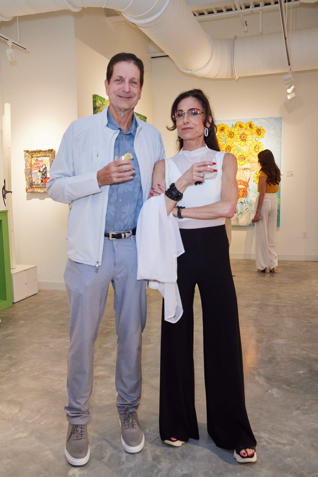 NORA District grand opening crowd in front of wall featuring Isabelle Scheltjens and Nemo Jantzen portraits.