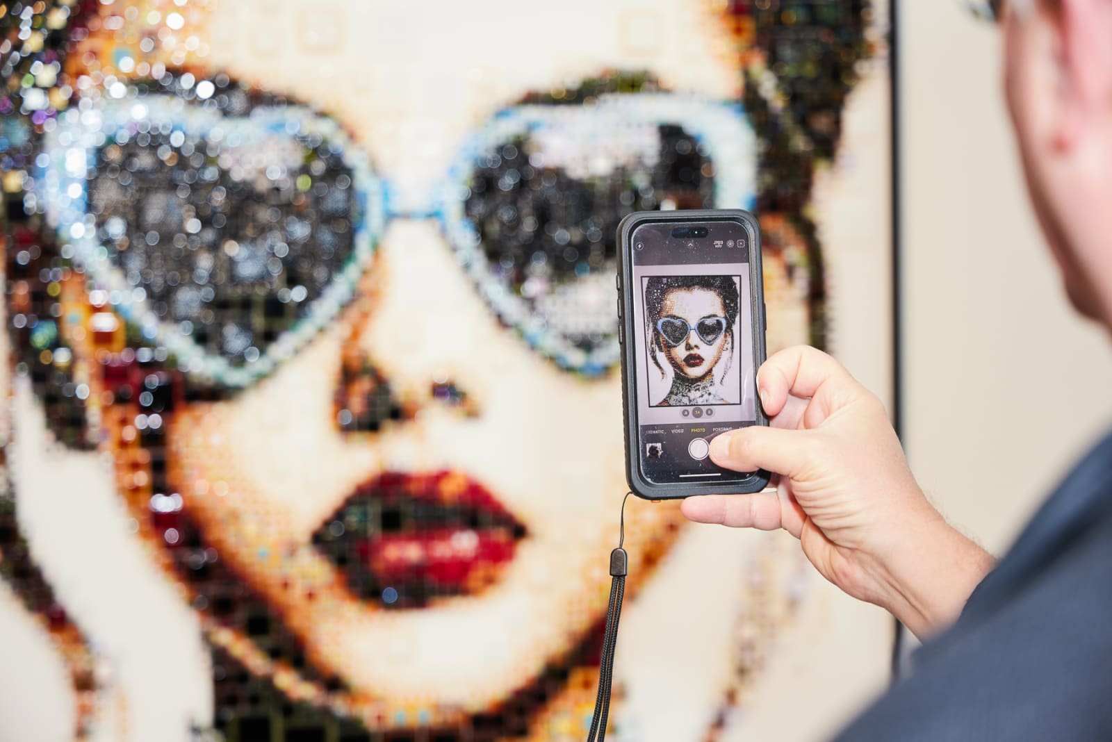 Isabelle Scheltjens glass mosaic portrait glowing under gallery lights at West Palm Beach NORA grand opening.