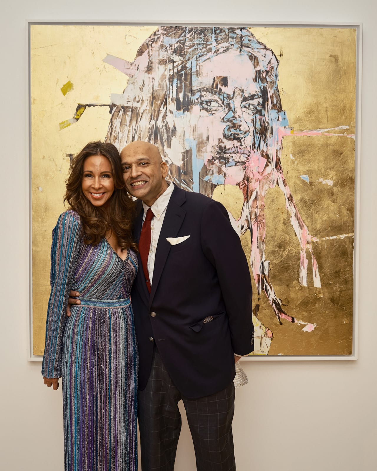 Real estate brokers conversing while Marco Grassi hyperreal portrait hangs further down the wall.